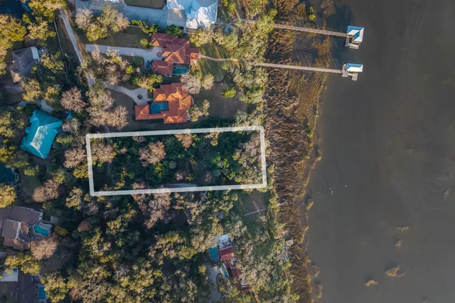 an aerial view of ocean and residential houses with outdoor space