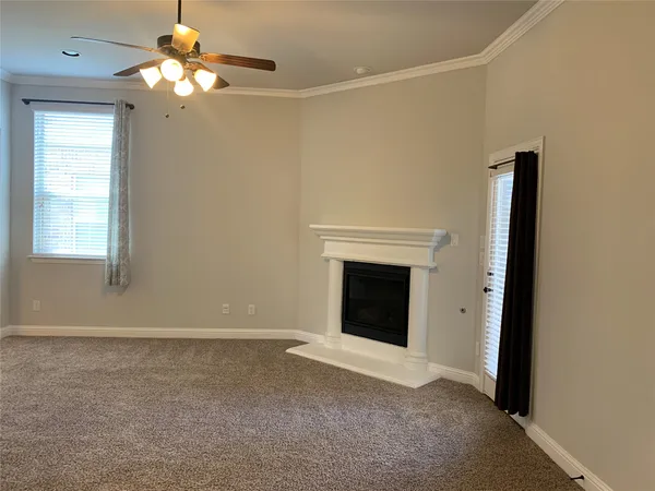 a view of a livingroom with a fireplace and a ceiling fan