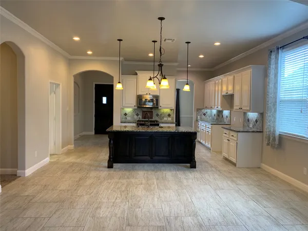 a large kitchen with a large counter top appliances and cabinets