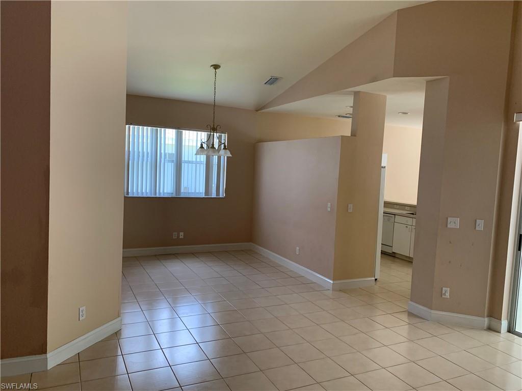 697 Crossfield Circle Naples, FL 34104 - Photo 4 of 12 an empty room with chandelier fan and windows