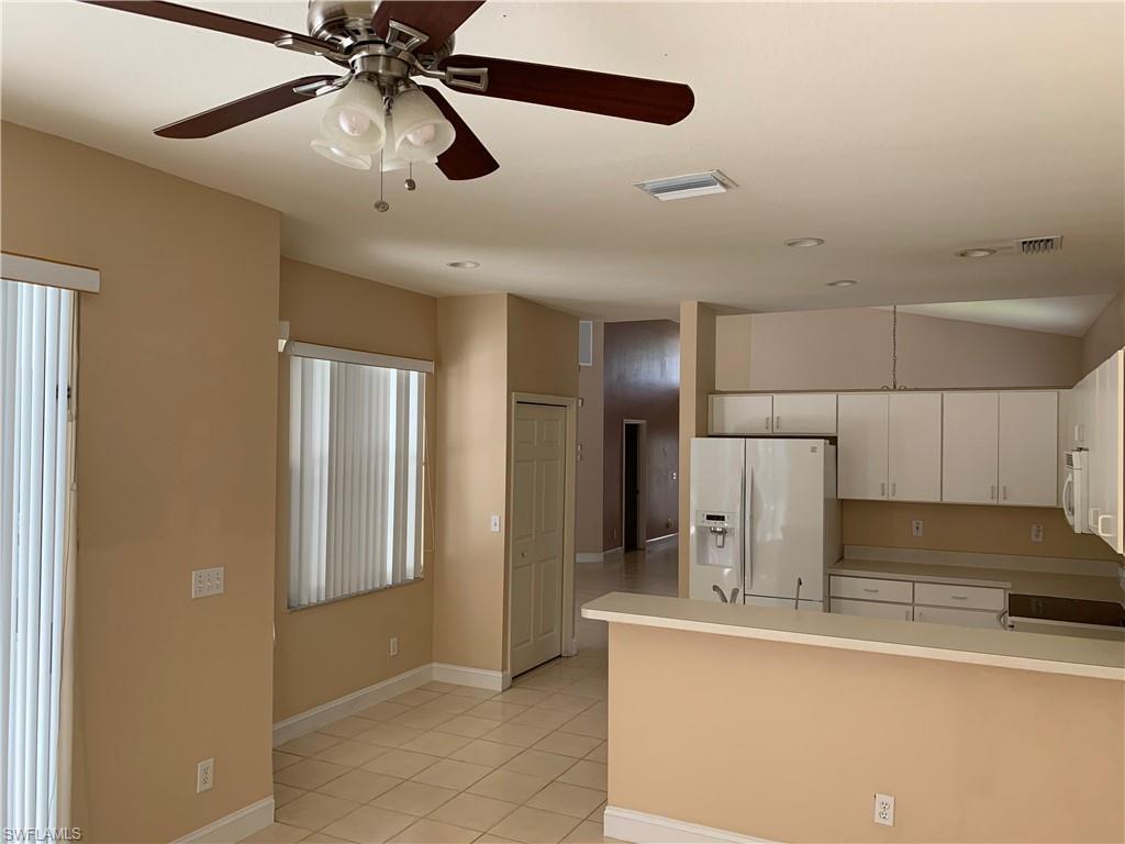 697 Crossfield Circle Naples, FL 34104 - Photo 6 of 12 a kitchen with a refrigerator and countertop