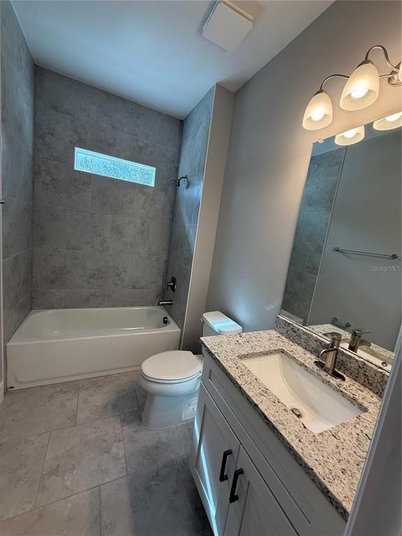 1569 Kerman Street North Port, FL 34288 - Photo 18 of 26 a bathroom with a granite countertop sink a toilet and bathtub