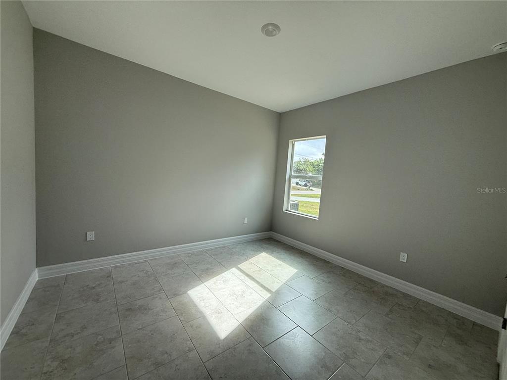 1569 Kerman Street North Port, FL 34288 - Photo 19 of 26 an empty room with windows and chandelier fan
