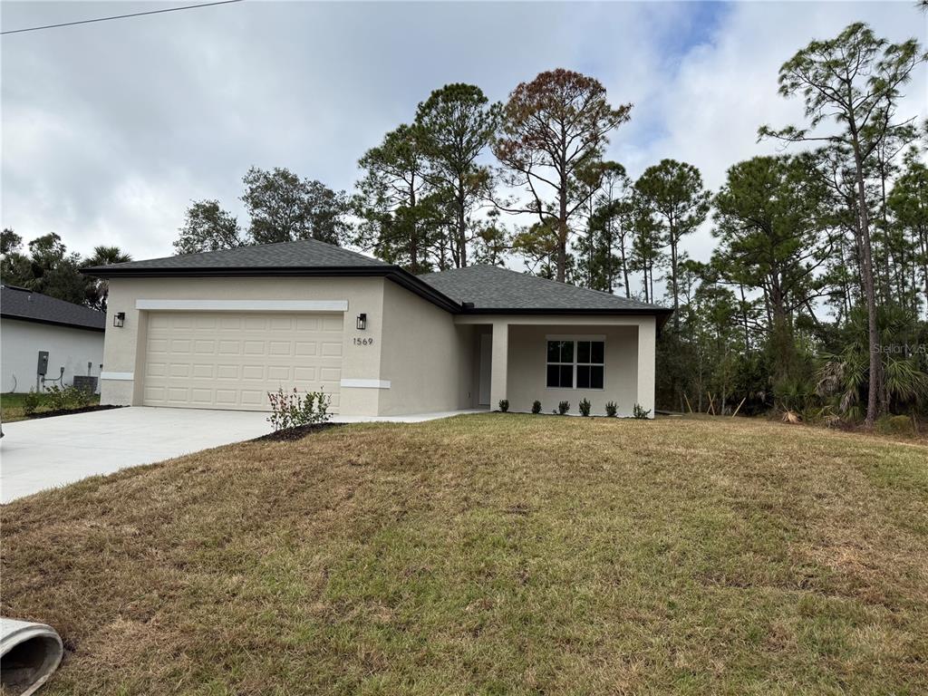 1569 Kerman Street North Port, FL 34288 - Photo 2 of 26 a front view of a house with garden