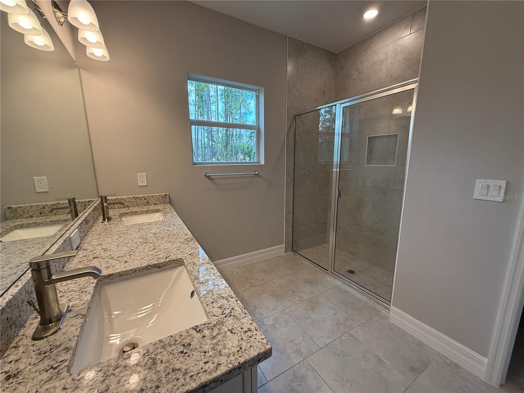 1569 Kerman Street North Port, FL 34288 - Photo 9 of 26 a bathroom with a granite countertop sink a mirror and shower