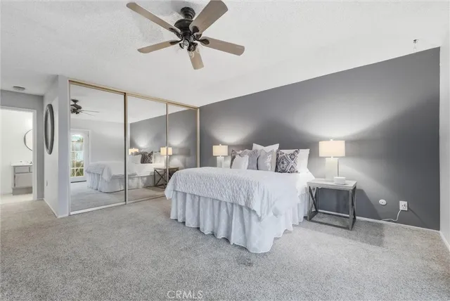 a spacious bedroom with a bed and a chandelier