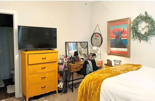 a bedroom with two beds and a flat screen tv