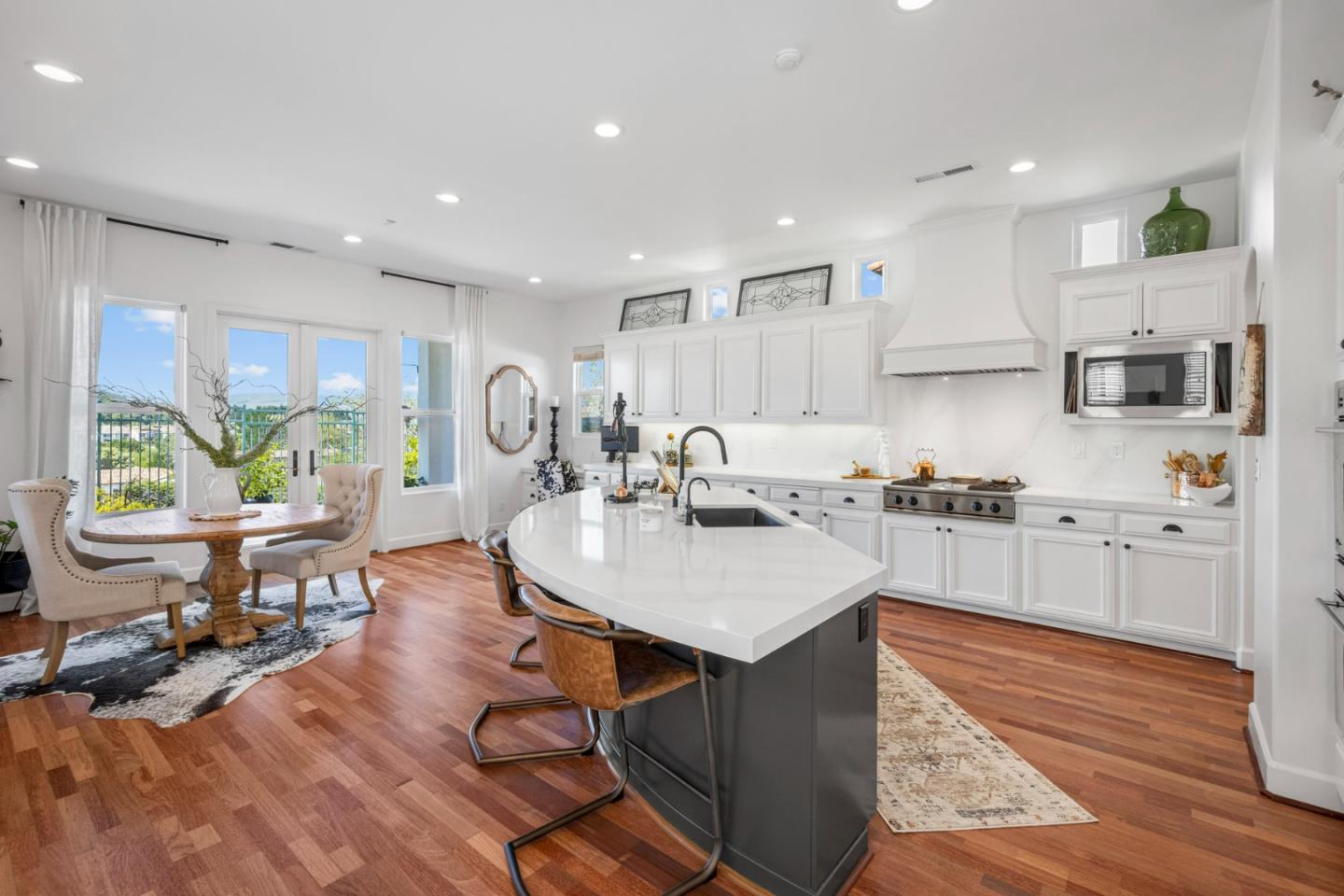 1913 St Andrews Circle Gilroy, CA 95020 - Photo 20 of 79 a kitchen with stainless steel appliances granite countertop a stove top oven a sink a refrigerator white cabinets and couches with wooden floor