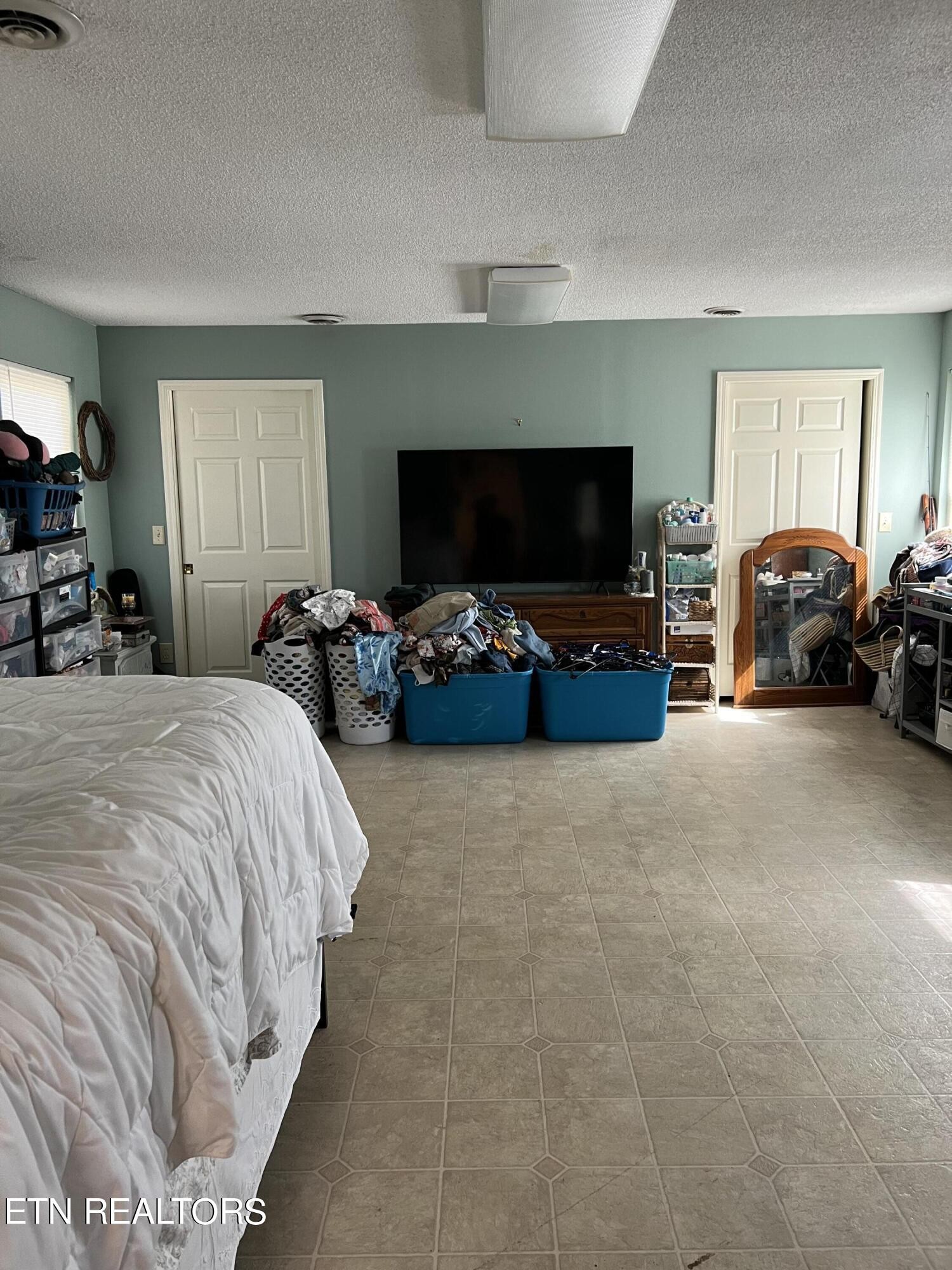 306 Englewood Road Madisonville, TN 37354 - Photo 19 of 34 a spacious bedroom with a bed and a flat screen tv