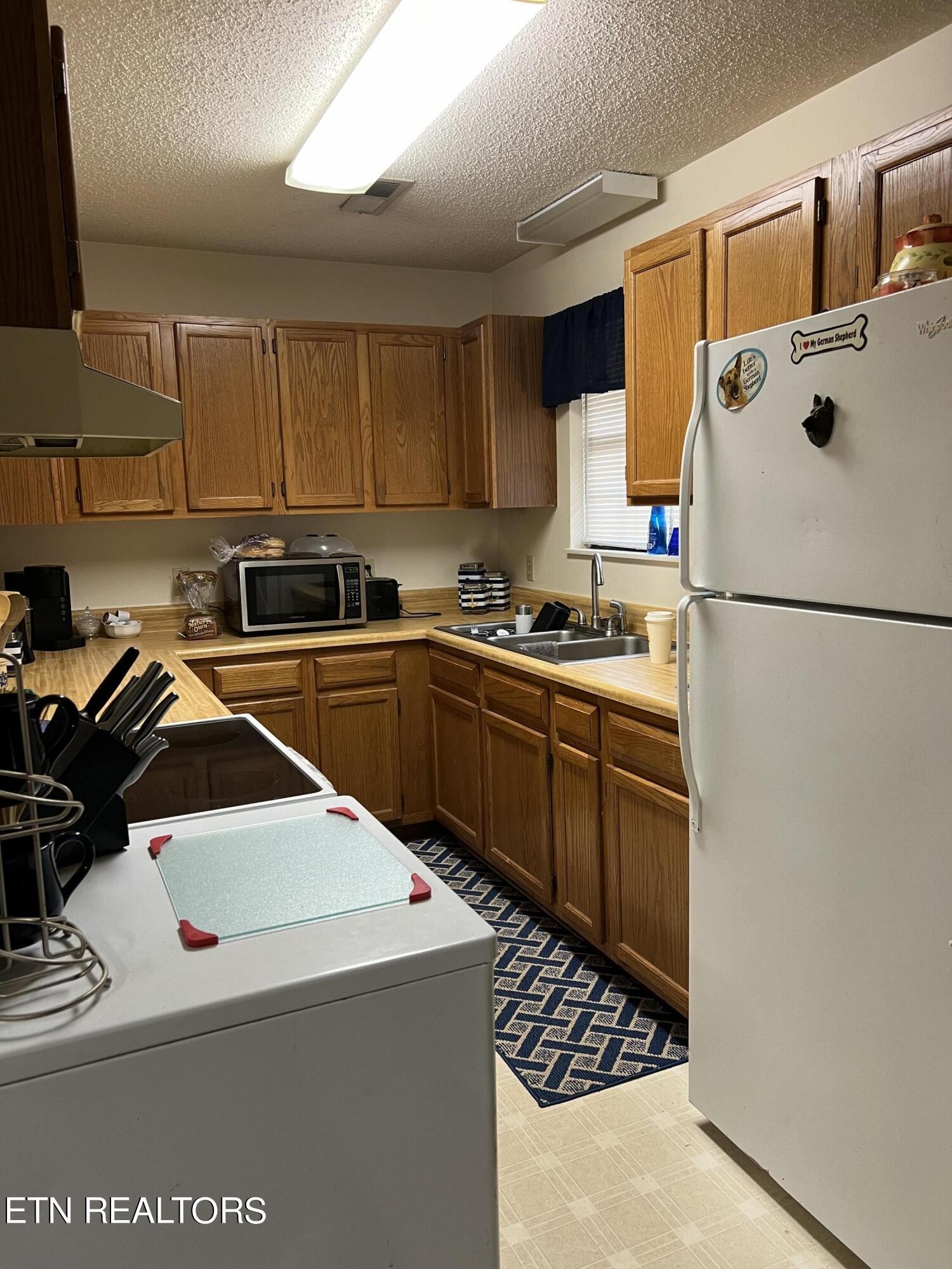 306 Englewood Road Madisonville, TN 37354 - Photo 34 of 34 a kitchen with a sink a stove a refrigerator and cabinets