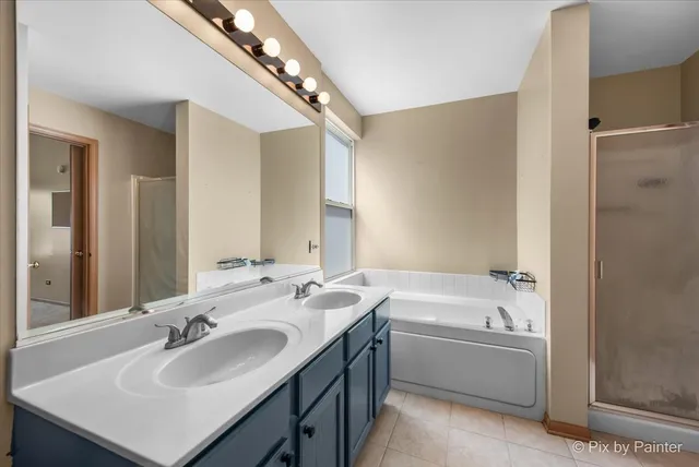 a bathroom with a sink double vanity mirror and a bathtub