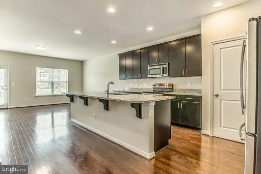 a kitchen with stainless steel appliances granite countertop a refrigerator and a stove top oven