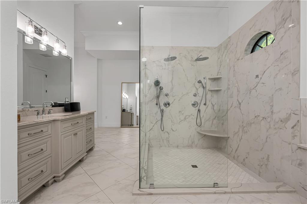 6689 Hunters Road Naples, FL 34109 - Photo 11 of 35 a bathroom with a shower sink and mirror