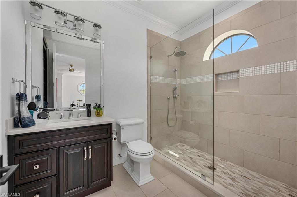 6689 Hunters Road Naples, FL 34109 - Photo 28 of 35 a bathroom with a sink a toilet a mirror and shower