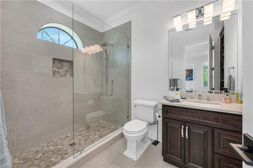 6689 Hunters Road Naples, FL 34109 - Photo 30 of 35 a bathroom with a sink a toilet a mirror and shower