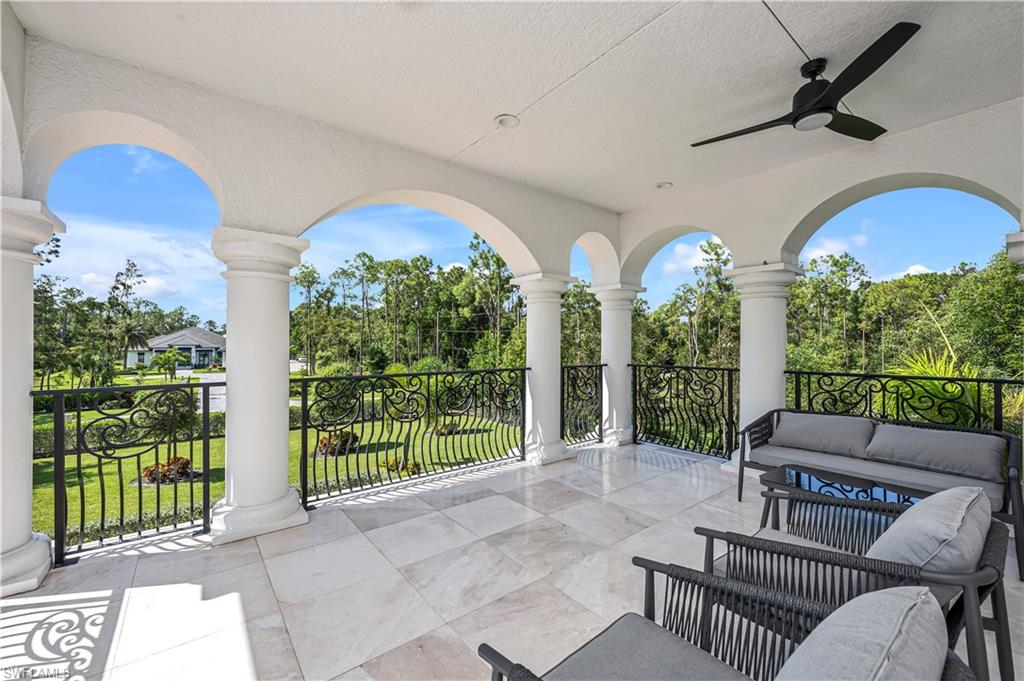 6689 Hunters Road Naples, FL 34109 - Photo 32 of 35 a living room with furniture and a floor to ceiling window