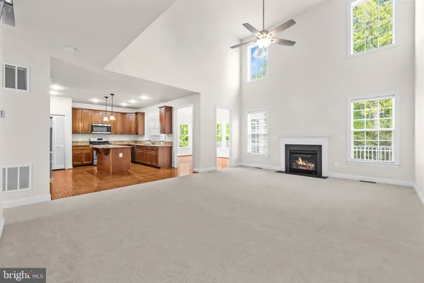 a kitchen with stainless steel appliances granite countertop a refrigerator a sink dishwasher a s stove top oven a large island with wooden cabinets and floor
