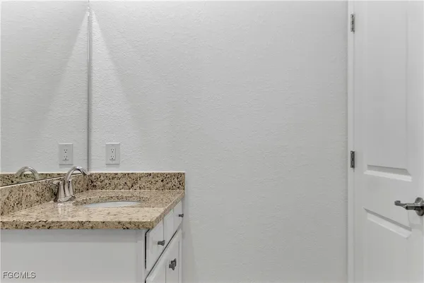 a kitchen with kitchen island granite countertop a refrigerator a sink a stove a microwave and island