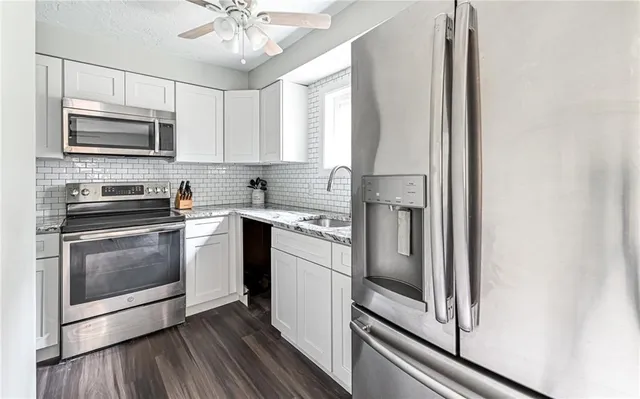a kitchen with stainless steel appliances a stove microwave and sink