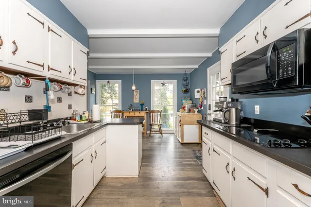 a kitchen with stainless steel appliances a sink dishwasher stove microwave and cabinets