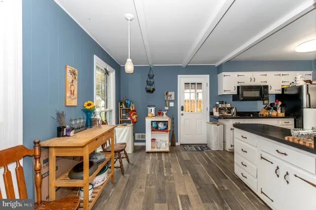 a view of a kitchen with furniture and wooden floor