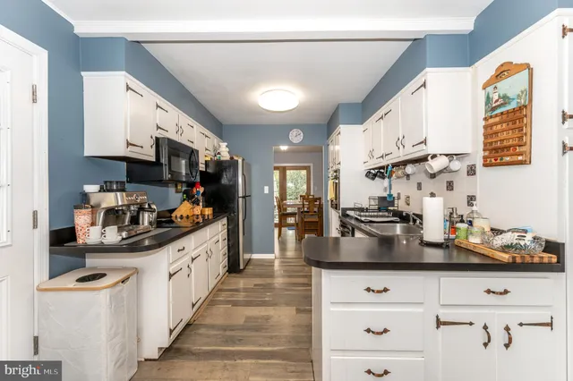 a kitchen with stainless steel appliances kitchen island granite countertop a sink dishwasher stove and cabinets