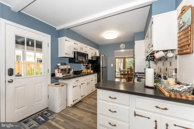 a kitchen with granite countertop a sink dishwasher stove and cabinets