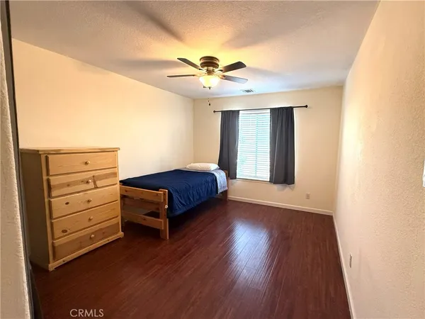 a bedroom with a bed and a ceiling fan