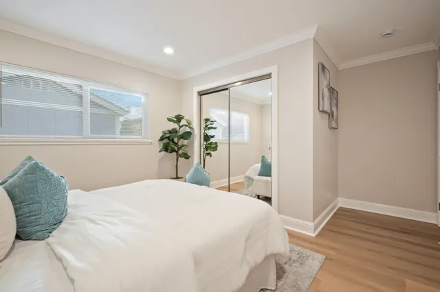 a bedroom with a large bed and wooden floor