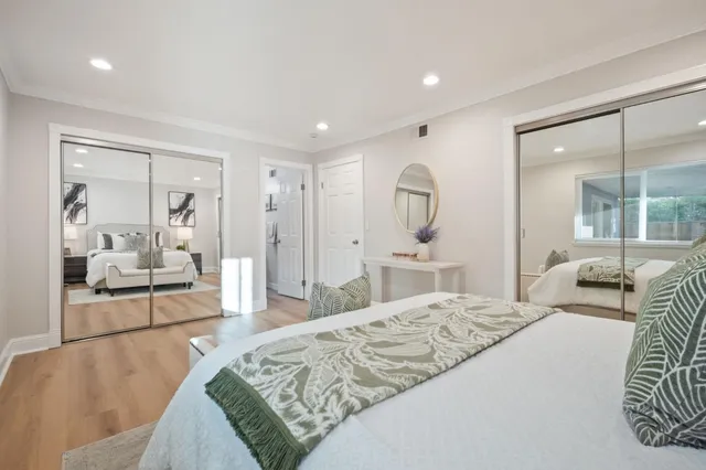 a spacious bedroom with a large bed and a large mirror