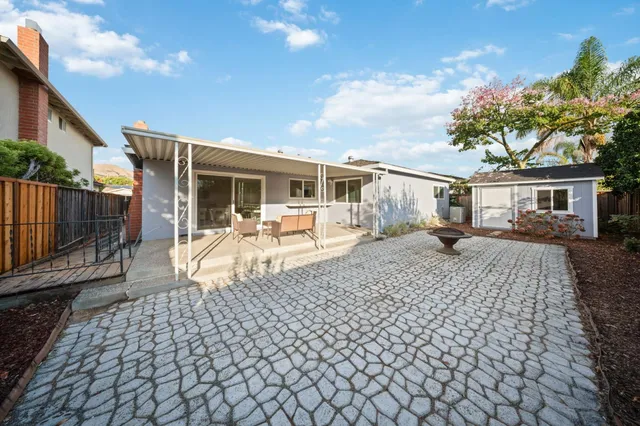 a view of a house with backyard and sitting area