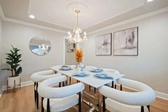 a dining room with furniture a chandelier and window