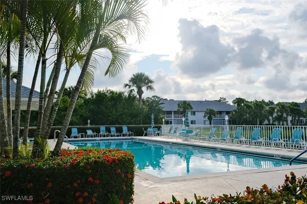 a view of swimming pool with a table and chairs under an umbrella