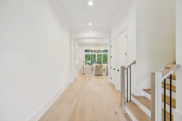 a living room with furniture a chandelier and a dining table with wooden floor