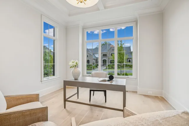 a living room with furniture potted plant and kitchen view