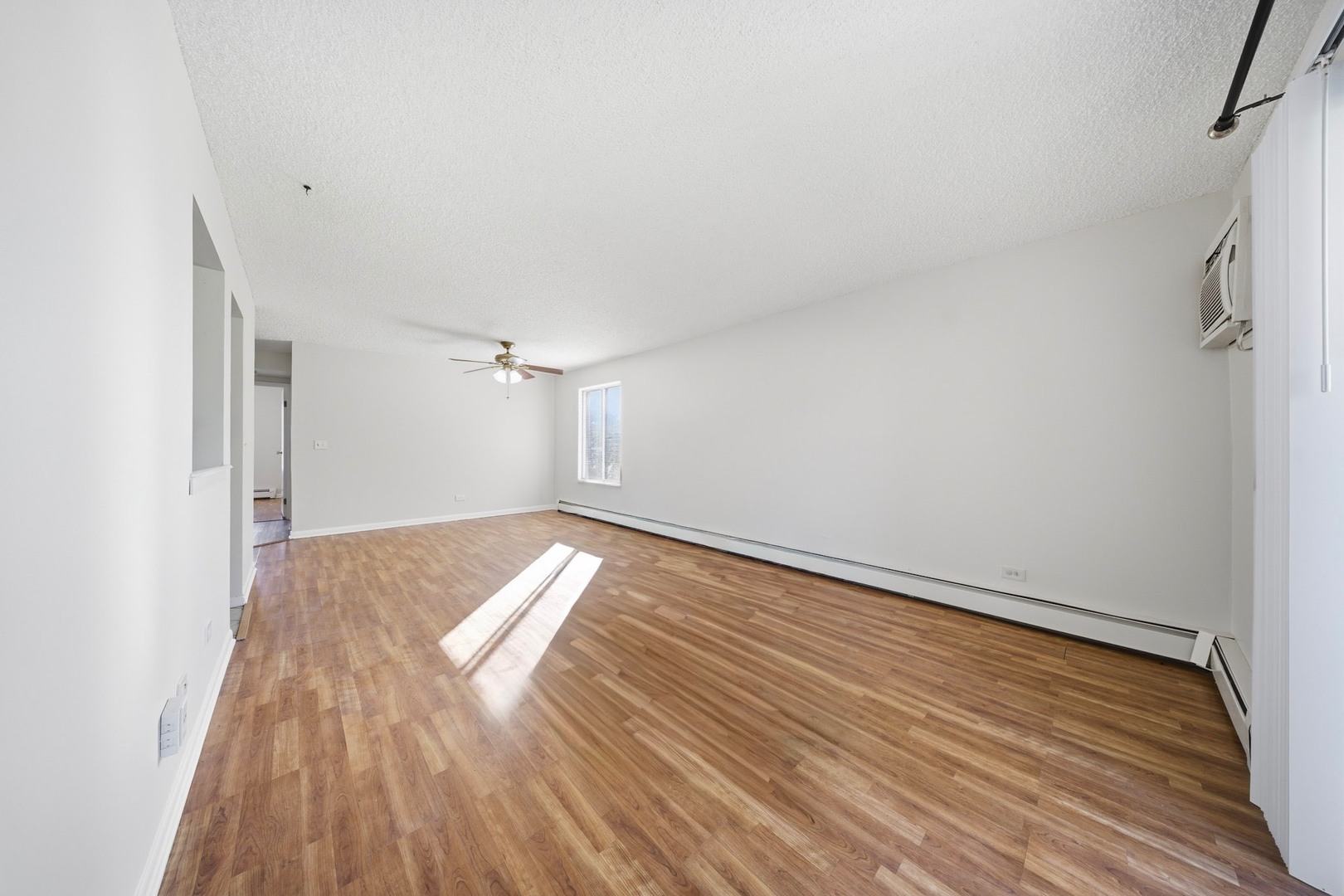 291 North Gregory Street, Unit 6 Aurora, IL 60504 - Photo 10 of 27 a view of empty room with wooden floor and fan