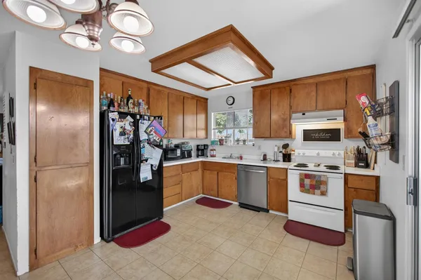 a kitchen with stainless steel appliances granite countertop a refrigerator a stove top oven a sink and dishwasher