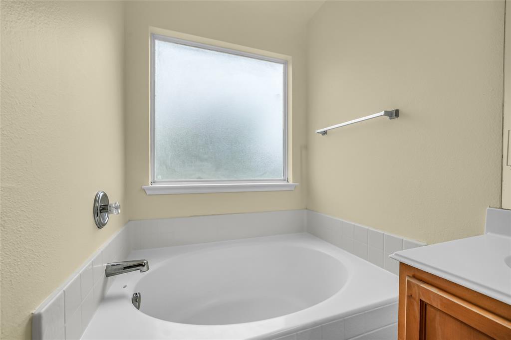 705 Loftin Street Crowley, TX 76036 - Photo 21 of 31 Bathroom with a bath, vanity, and a textured wall