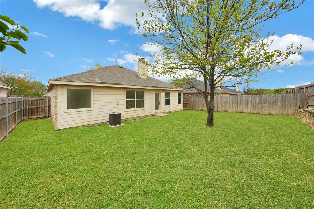 705 Loftin Street Crowley, TX 76036 - Photo 30 of 31 Rear view of property featuring a fenced backyard and a chimney