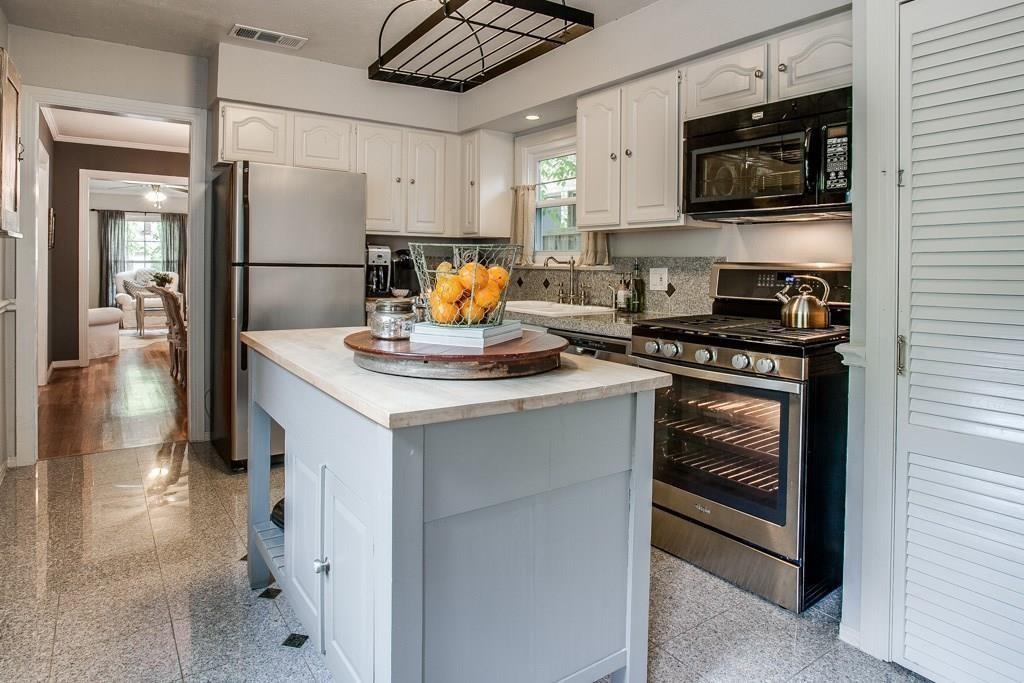 6043 Llano Avenue Dallas, TX 75206 - Photo 11 of 40 a kitchen with stainless steel appliances a stove microwave and a refrigerator