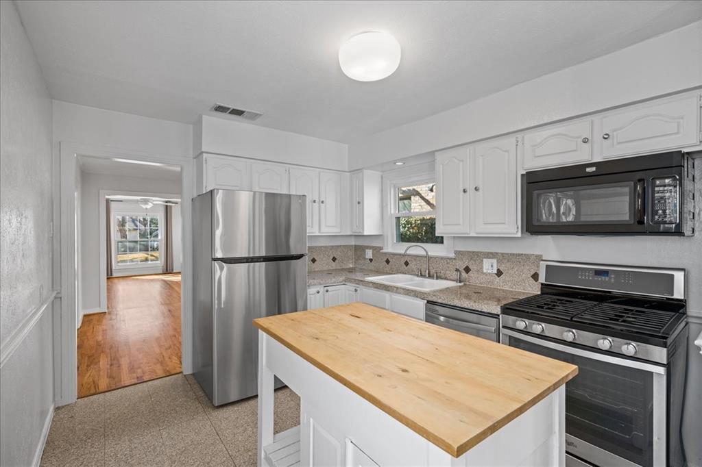 6043 Llano Avenue Dallas, TX 75206 - Photo 13 of 40 a kitchen with stainless steel appliances granite countertop a refrigerator stove microwave and sink