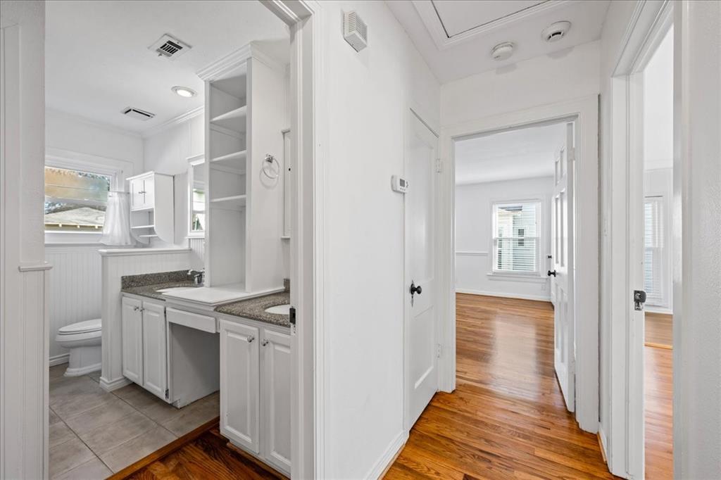 6043 Llano Avenue Dallas, TX 75206 - Photo 21 of 40 a kitchen with white cabinets and wooden floor