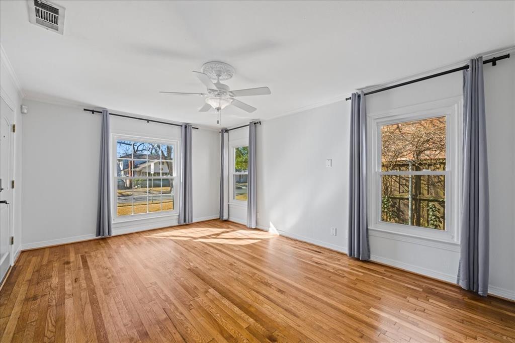 6043 Llano Avenue Dallas, TX 75206 - Photo 5 of 40 a view of an empty room with a window and wooden floor