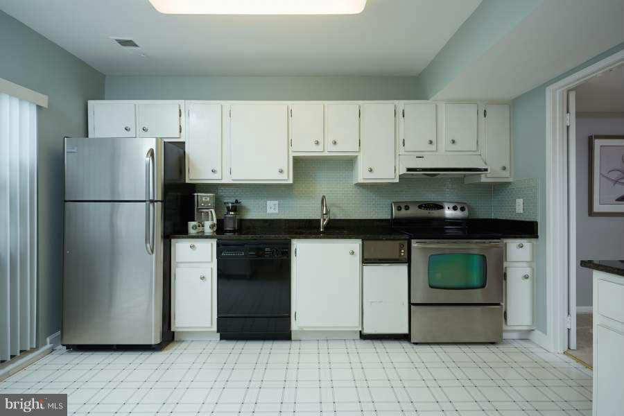 11602 Windbluff Court, Unit 8A1 Reston, VA 20191 - Photo 11 of 27 a kitchen with a refrigerator sink and cabinets