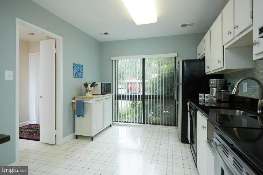 11602 Windbluff Court, Unit 8A1 Reston, VA 20191 - Photo 13 of 27 a kitchen with a sink stove and cabinets