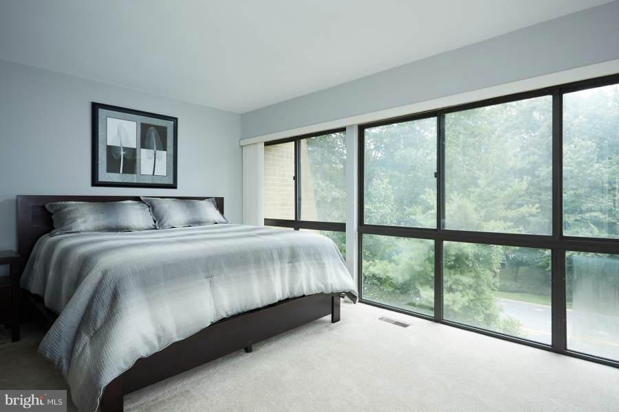 11602 Windbluff Court, Unit 8A1 Reston, VA 20191 - Photo 15 of 27 a bedroom with a bed and a large window
