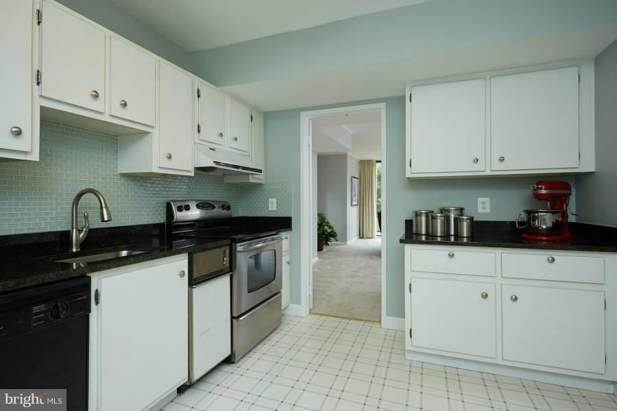 11602 Windbluff Court, Unit 8A1 Reston, VA 20191 - Photo 10 of 27 a kitchen with granite countertop white cabinets and stainless steel appliances