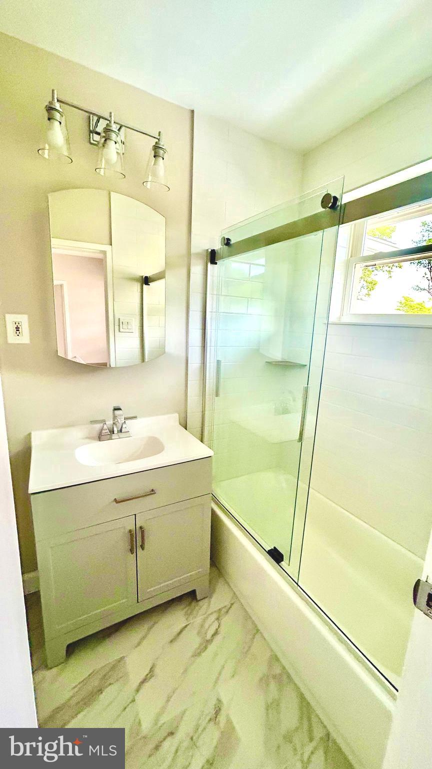5319 Pooks Hill Road, Unit 1 Bethesda, MD 20814 - Photo 27 of 37 a bathroom with a tub a sink and a mirror