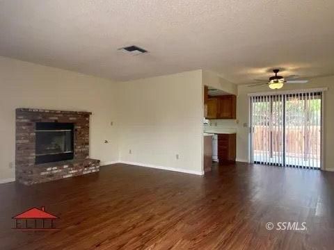 1004 West Perdew Avenue Ridgecrest, CA 93555 - Photo 3 of 14 a view of an empty room with wooden floor fireplace and a window
