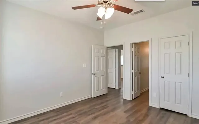 a view of an empty room with wooden floor